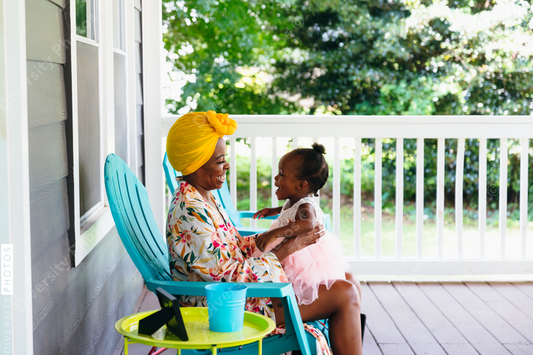 Beautiful mother and daughter sitting on front porch