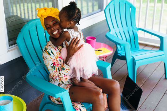 Beautiful mother and daughter sitting on front porch