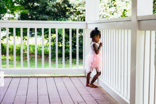 Young ballerina playing on front porch at home bored during pandemic