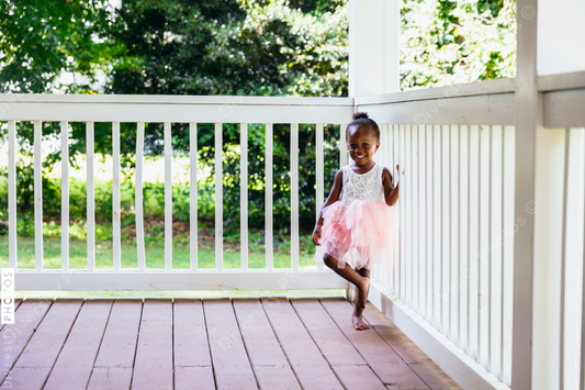 Young ballerina playing on front porch at home