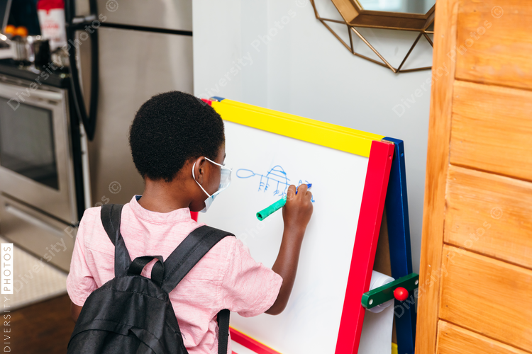Young boy drawing on board at home for school