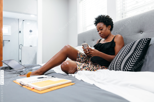 Woman working remotely from home in bed