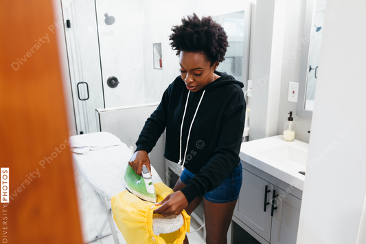Black woman doing house chores and ironing children's clothes