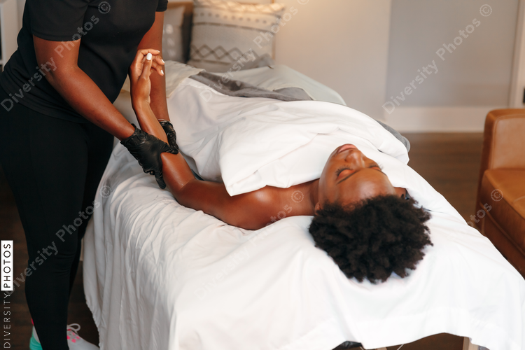 Black woman getting relaxing massage from black masseuse