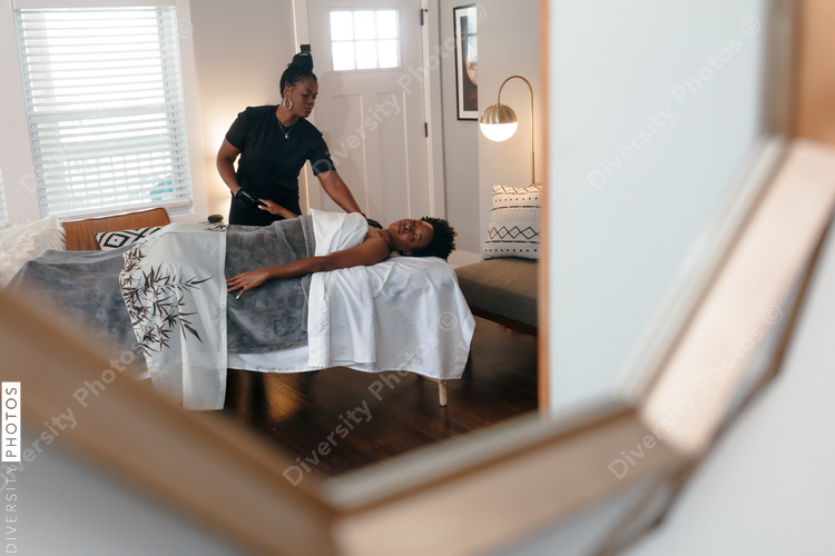 Black woman getting relaxing massage from black masseuse