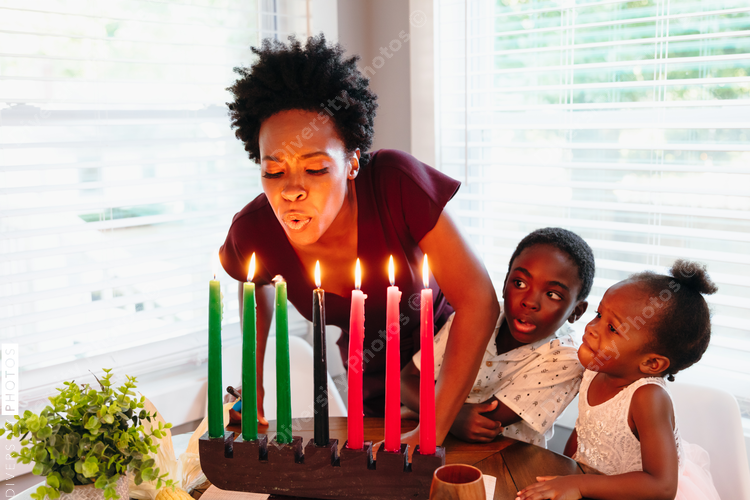 Mother  with children blowing Kwanza candles
