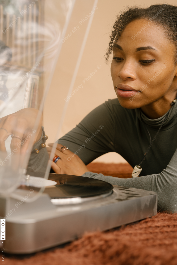 Black woman playing music through vintage vinyl records