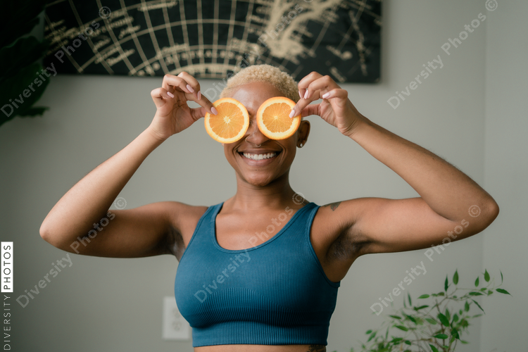 Happy and healthy young woman holding orange slices