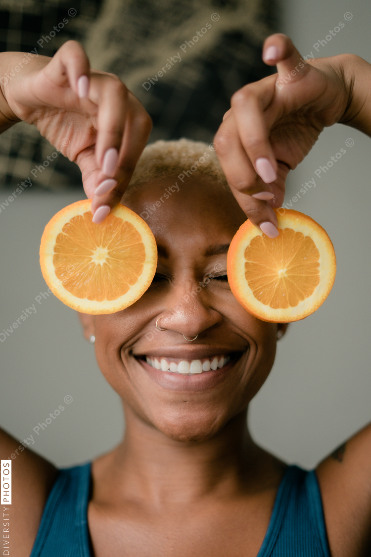 Happy and healthy young woman holding orange slices