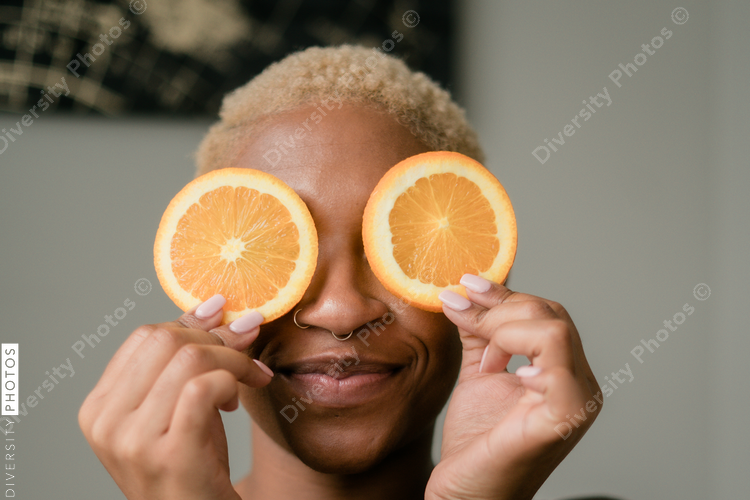 Happy and healthy young woman holding orange slices