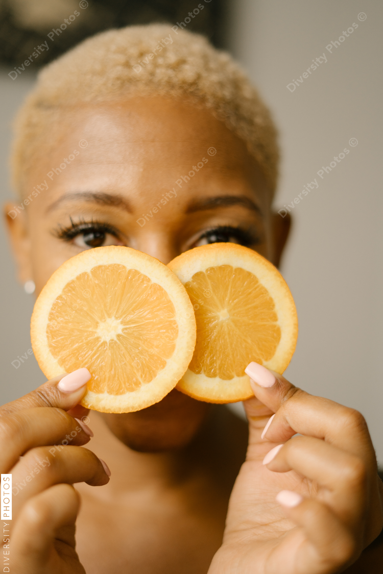 Happy and healthy young woman holding orange slices
