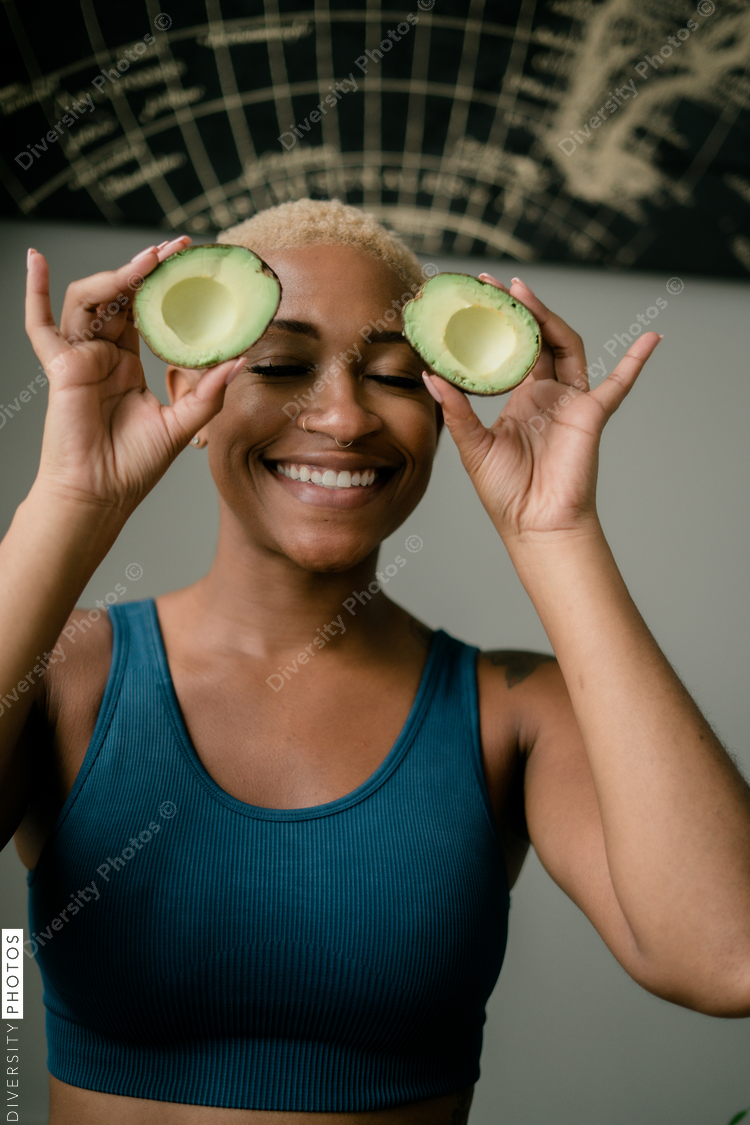 Happy and healthy young woman holding avocado