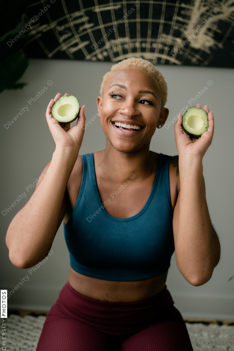 Happy and healthy young woman holding avocado