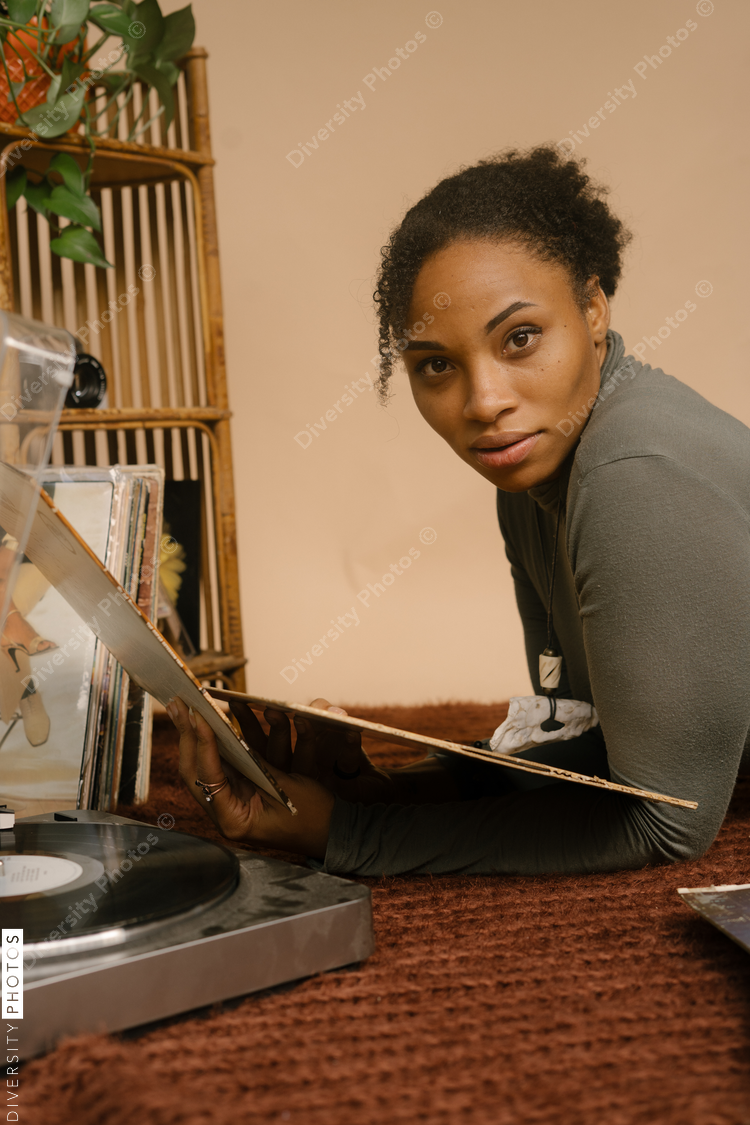 Black woman listening to music through vintage vinyl records