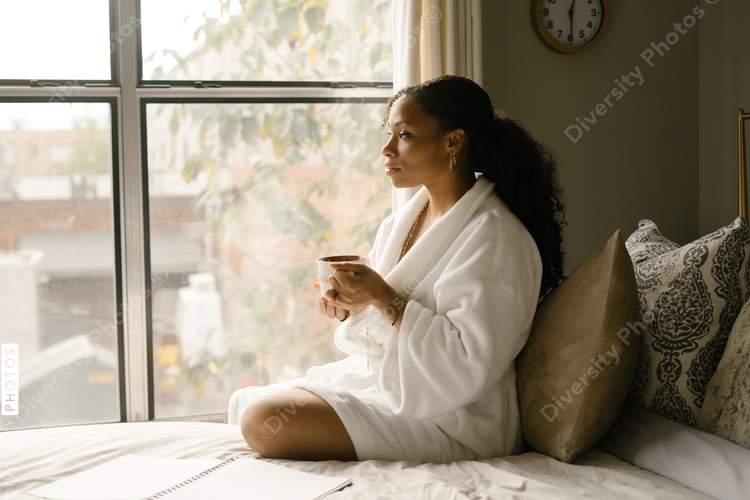 Woman drinking coffee at home in bed