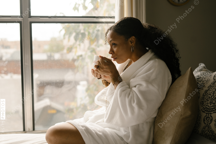 Woman drinking coffee at home in bed