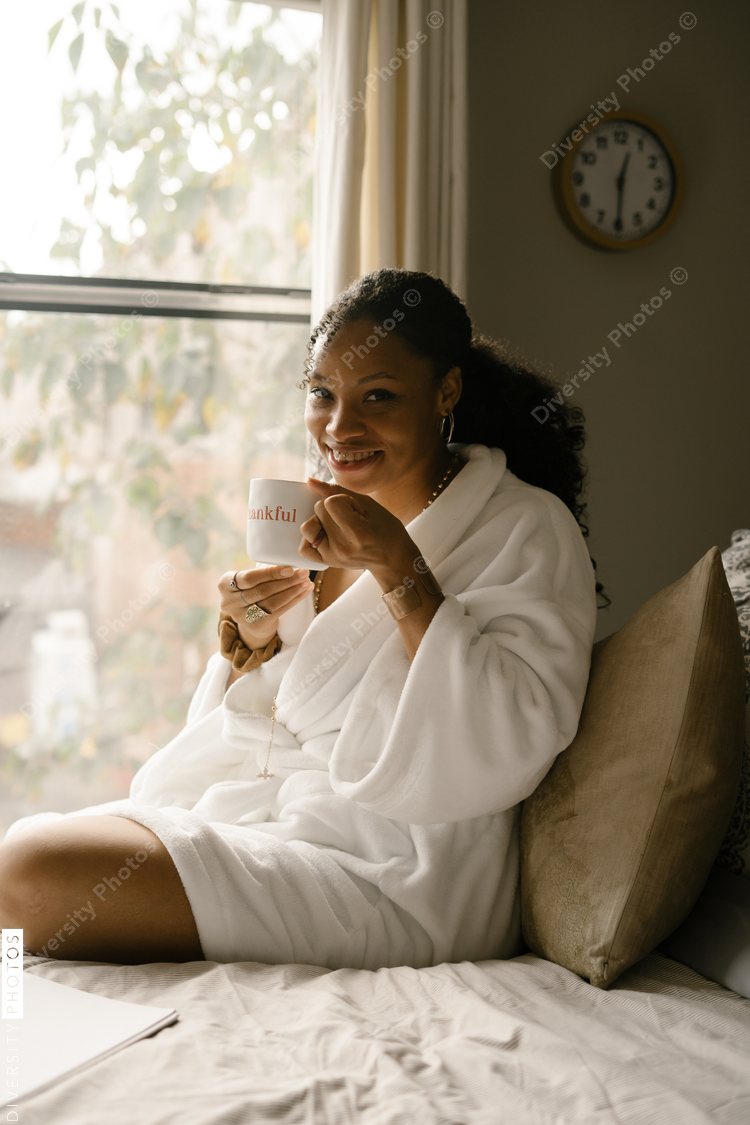 Woman drinking coffee at home in bed