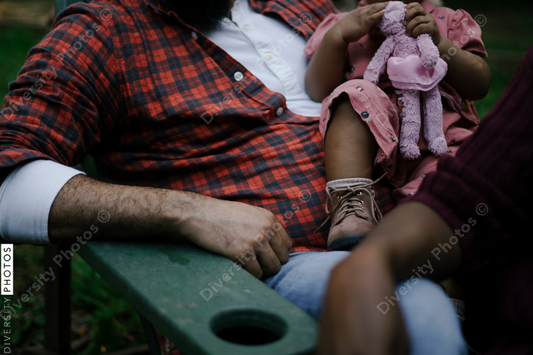 Black father and daughter sitting outdoors in backyard