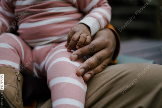 Black father and daughter sitting outdoors in backyard