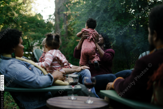 Black friends safely gathered and enjoying a backyard kickback party with children