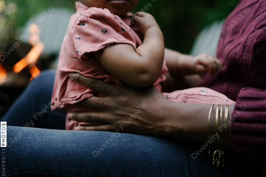 Black child sitting in lap of mother outside