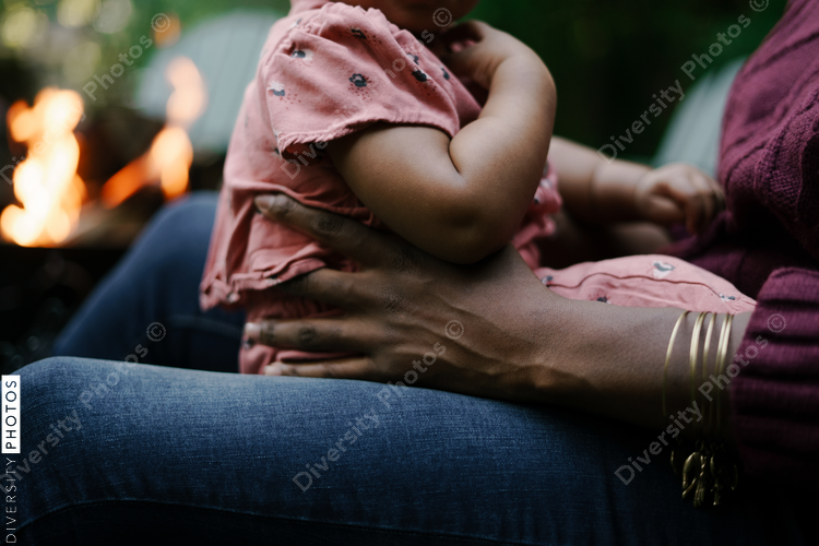 Mother and daughter outdoors sitting next to firepit at home