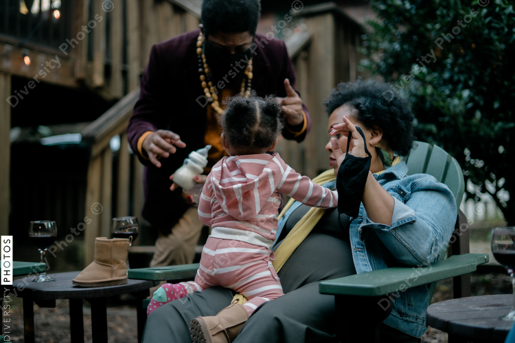 Mom and dad entertaining daughter at friends kickback barbecue