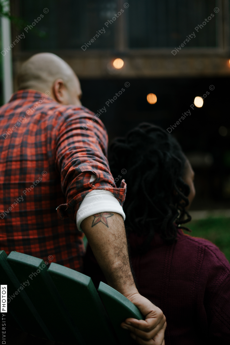 Friends gathered for evening party in backyard around firepit