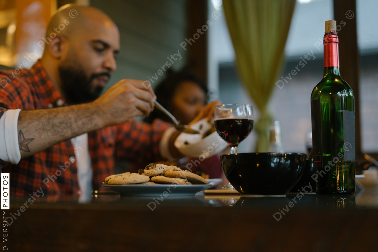Black friends enjoying dinner and wine together while on vacation