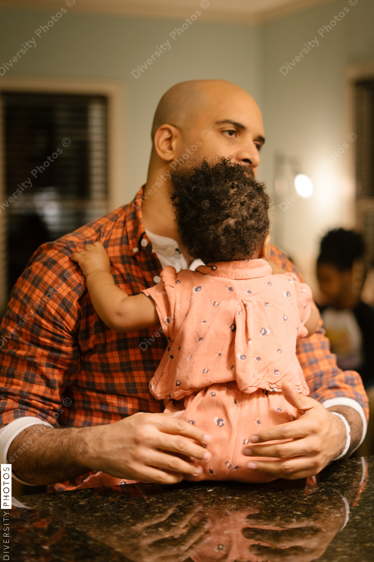 African American dad and daughter hanging out in the kitchen together