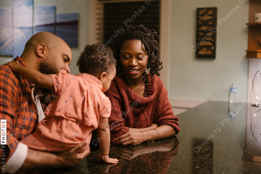 African American mom and dad spending quality time with daughter at home