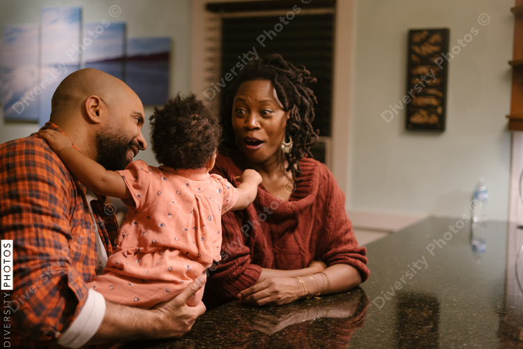 African American mom and dad laughing with daughter at home