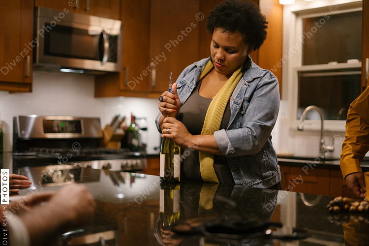 Woman opening wine bottle at party