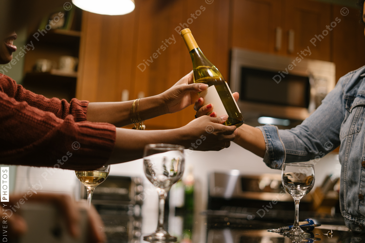 Friends having a drink together at house party gathering