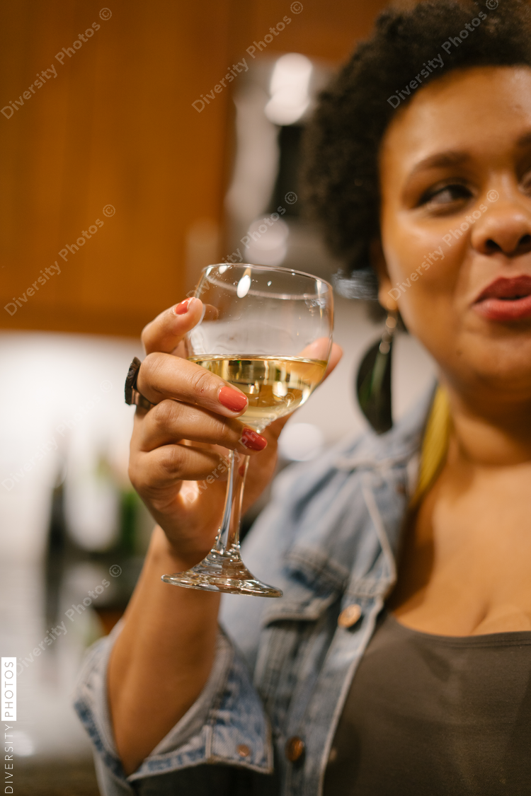 Friends having a drink together at house party gathering