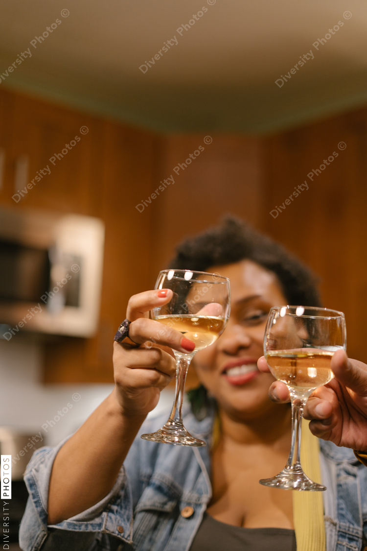 Black woman toasting with wine at a house party and get together with friends