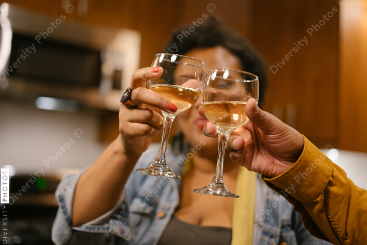 Black woman toasting with wine at a house party and get together with friends