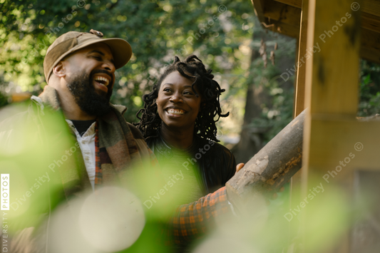 Black man and wife laughing getting firewood for fire-pit