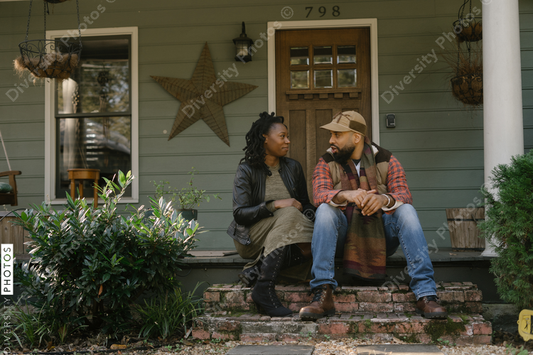 Beautiful black couple talking on front porch at home