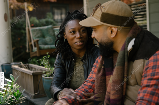 Beautiful black couple talking on front porch at home