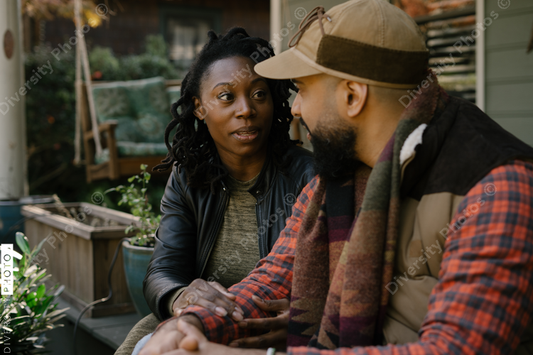 Beautiful black couple talking on front porch at home