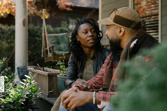 Beautiful black couple talking on front porch at home
