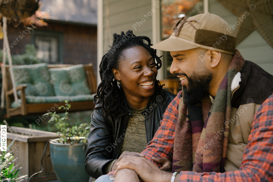 Beautiful black couple talking on front porch at home