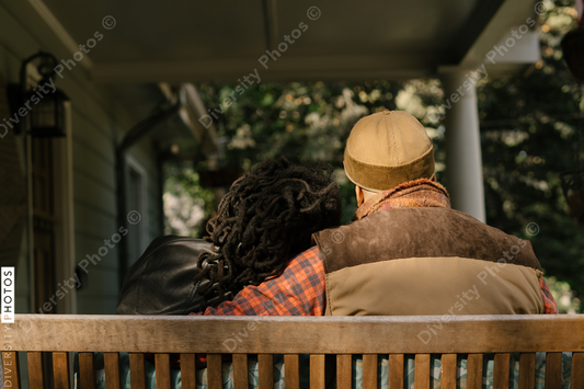 Black couple spending quality time together on front porch swing at home