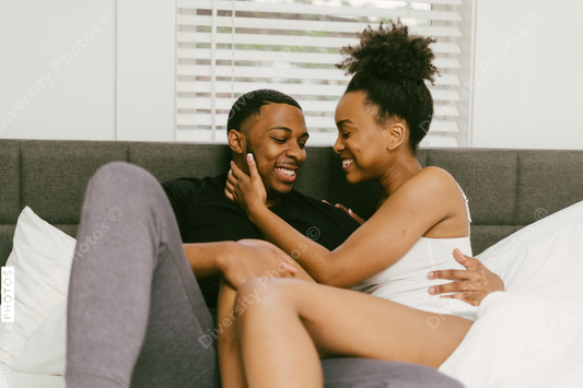 Black couple relaxing on bed at home, love connection