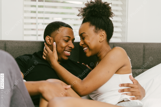 Black couple relaxing on bed at home, love connection