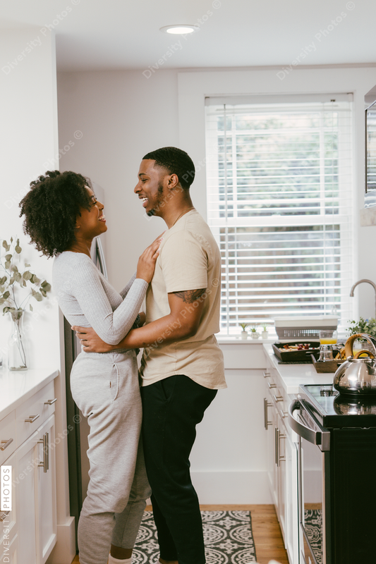 Black couple dancing in kitchen at home, intimate moment