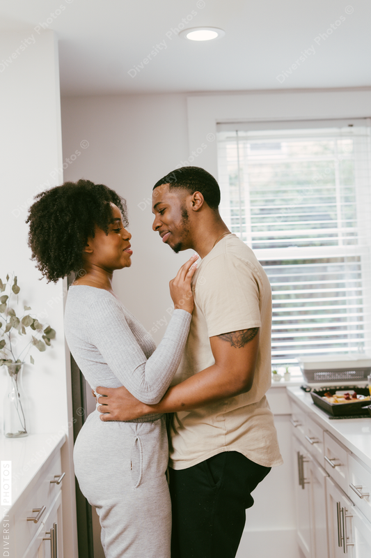 Black couple dancing in kitchen at home, intimate moment