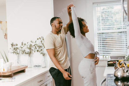 Black couple dancing in kitchen at home, intimate moment