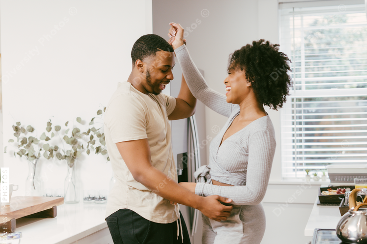 Black couple dancing in kitchen at home, intimate moment